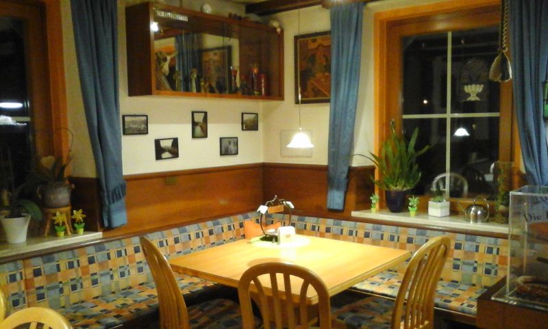 Warme Beleuchtung, blaue Vorhänge, Wandkunst und Zimmerpflanzen verstärken die einladende Atmosphäre.